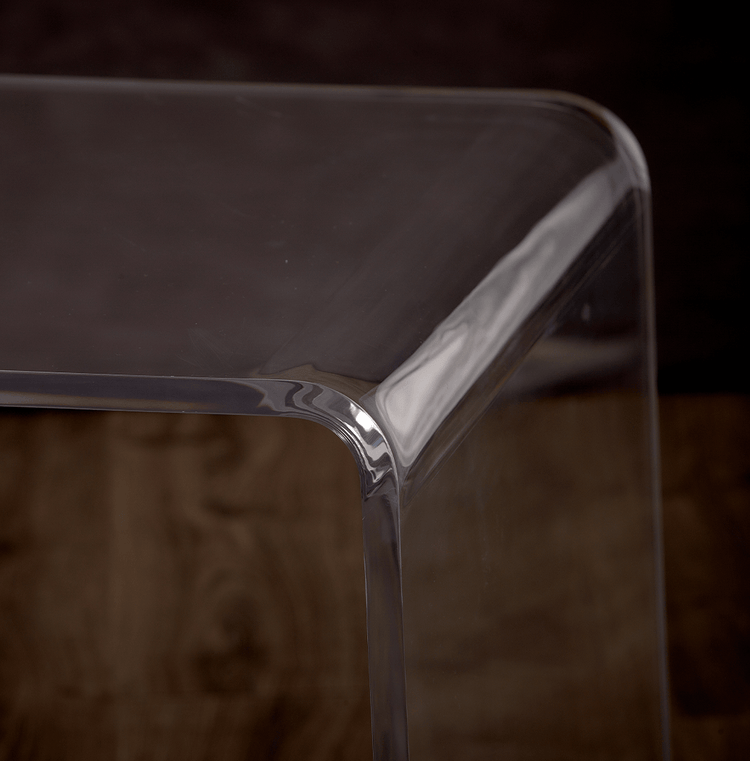 Close-up of the waterfall edges of a clear acrylic vanity or desk.