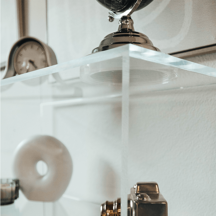 Closeup of the top corner on a clear acrylic lucite bookshelf to show clean, smooth edges.