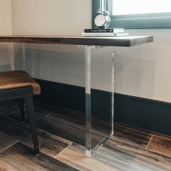 A closeup of acrylic lucite panel table legs under a wooden office desk table available for purchase to add to any existing tabletop.