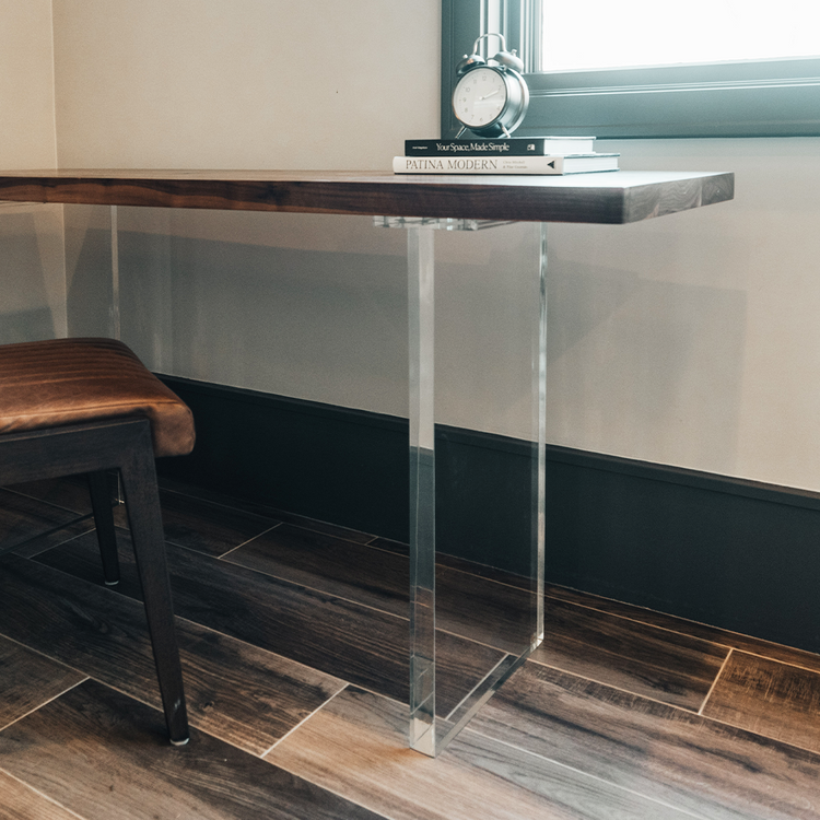 A closeup of acrylic lucite panel table legs under a wooden office desk table available for purchase to add to any existing tabletop.
