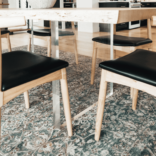A closeup of acrylic lucite panel table legs under a wooden dining table available for purchase to add to any existing tabletop.