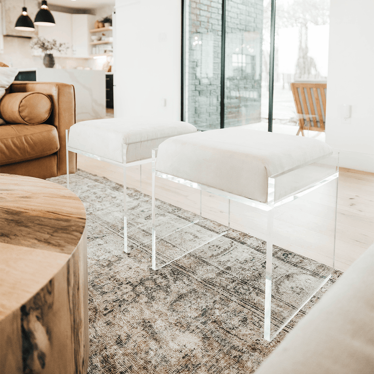 2 acrylic lucite upholstered accent chairs providing extra seating in a living room setting.