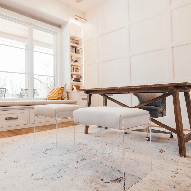 2 acrylic lucite upholstered accent chairs providing extra seating in an office setting.