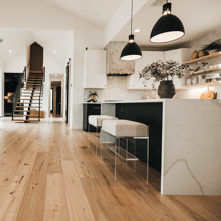 A set of two clear acrylic modern bar stools with white upholstered seats and clear acrylic legs, positioned at a kitchen island.