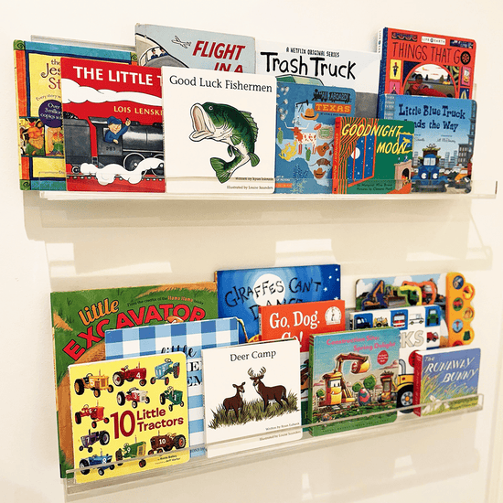 A set of clear acrylic floating bookshelves mounted on a wall, displaying various children's books.