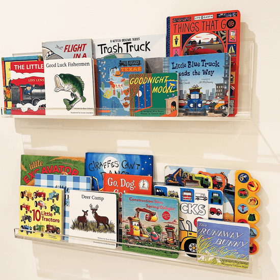 A set of clear acrylic floating bookshelves mounted on a wall, displaying various children's books.