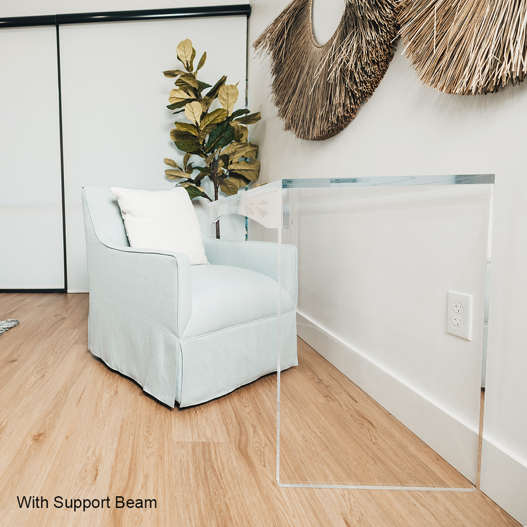 A light blue armchair slid up to a clear acrylic lucite slab desk that's against a decorated wall in a living room.