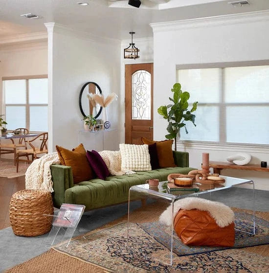 Fully furnished living room showing clear acrylic waterfall edge coffee table decorated with candles, books and coffee cups. Also featured is a clear acrylic magazine rack.