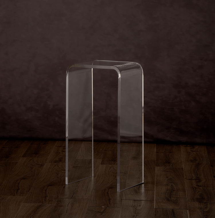 Catalog view of a clear acrylic waterfall edge end table on a hardwood floor.