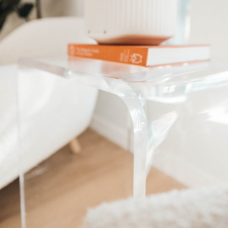 A closeup of the waterfall edge on a clear acrylic waterfall edge end table.