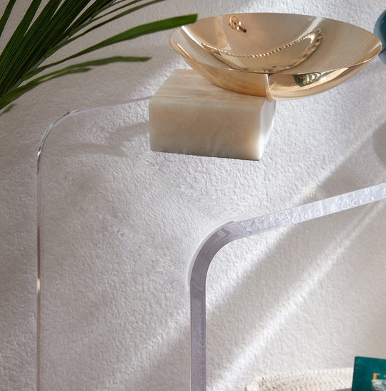 Closeup of the waterfall edge on a clear acrylic entry or hallway table displaying a decorative bowl.