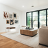 Two clear acrylic benches with brown cushions and storage shelf underneath, placed as extra seating in a modern living room with abstract art on the walls.