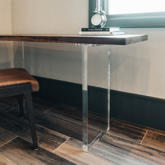 A closeup of acrylic lucite panel table legs under a wooden office desk table available for purchase to add to any existing tabletop. 