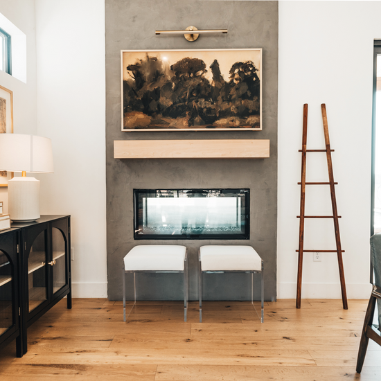 Modern living room with 2 clear acrylic accent chairs placed in front of a fireplace. 