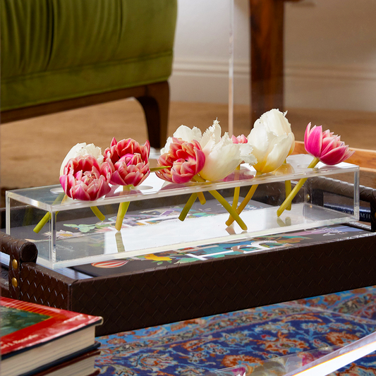 Clear acrylic horizontal short stem floral centerpiece displaying fresh cut flowers.