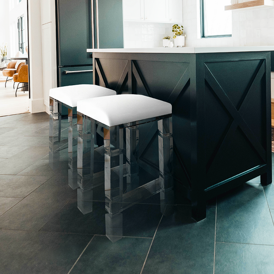  2 clear acrylic lucite barstools with white padded seats placed at a kitchen island.