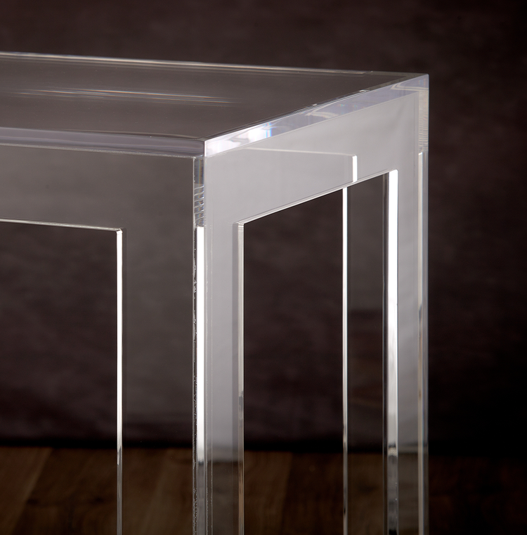 Catalog closeup of the square legs and top corner edge of a 20" clear acrylic coffee table.