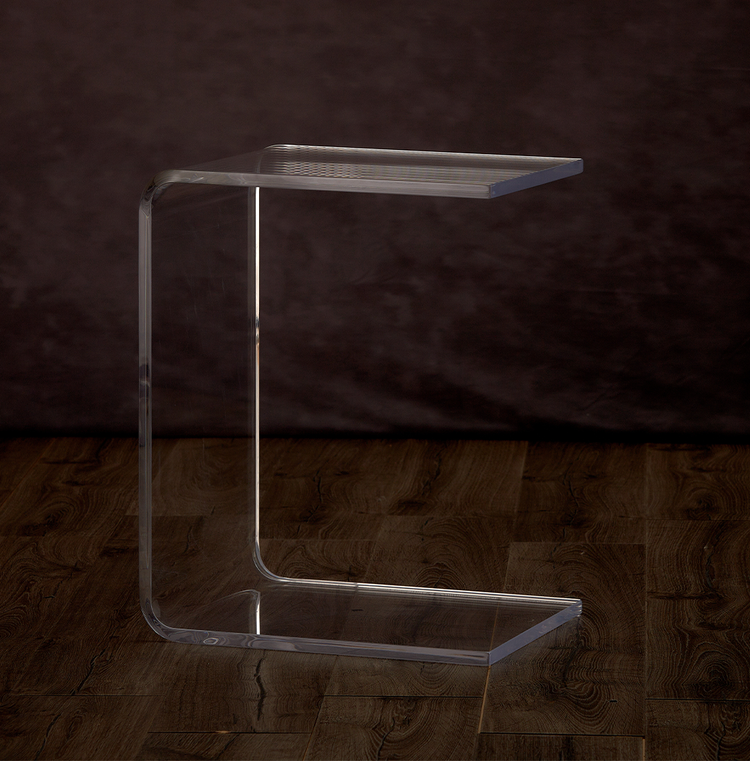 Catalog view of a clear acrylic open end, c-shaped end table on a hardwood floor.