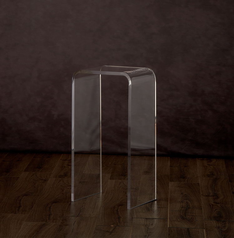 Catalog view of a clear acrylic waterfall edge end table on a hardwood floor.