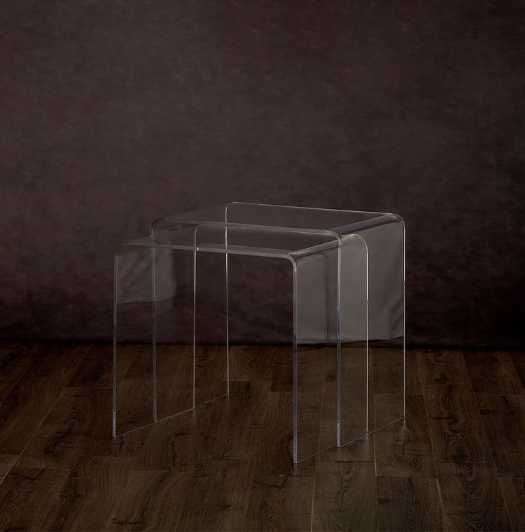 2 clear acrylic waterfall edge nesting end tables on a hardwood floor with lower table pulled out.
