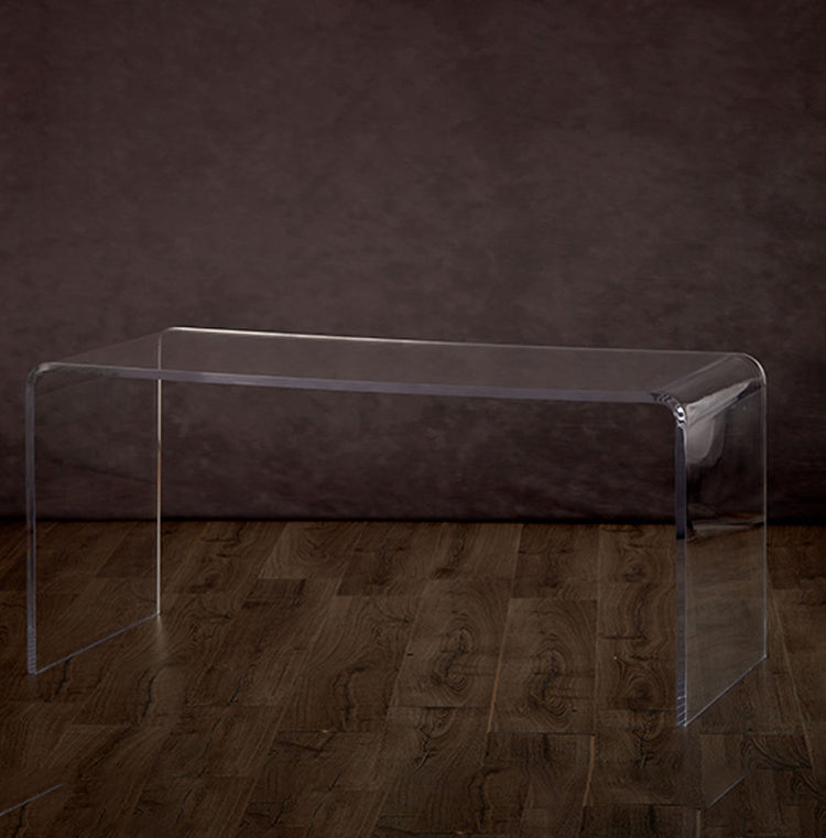 20" clear acrylic waterfall edge coffee table on a hardwood floor.